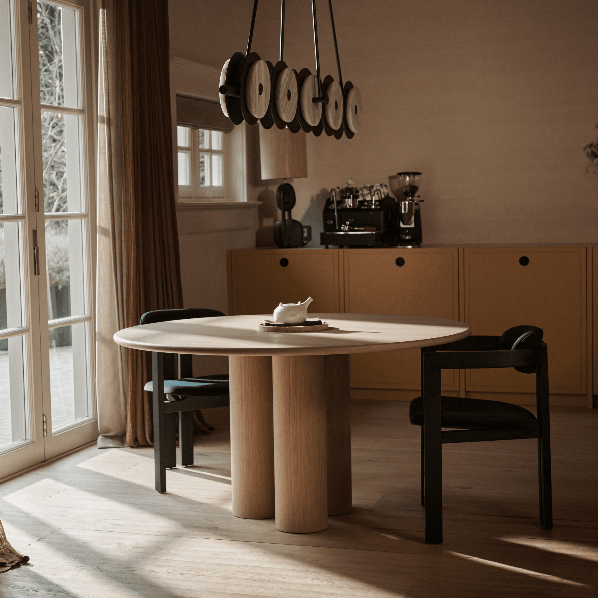 Black Aime Té Tribute dining chair with an off-white upholstered seat, showcasing a modern design and comfortable seating.