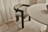 A black Aime Té Tribute dining chair with an off-white upholstered seat, showcasing a modern design and comfortable seating.