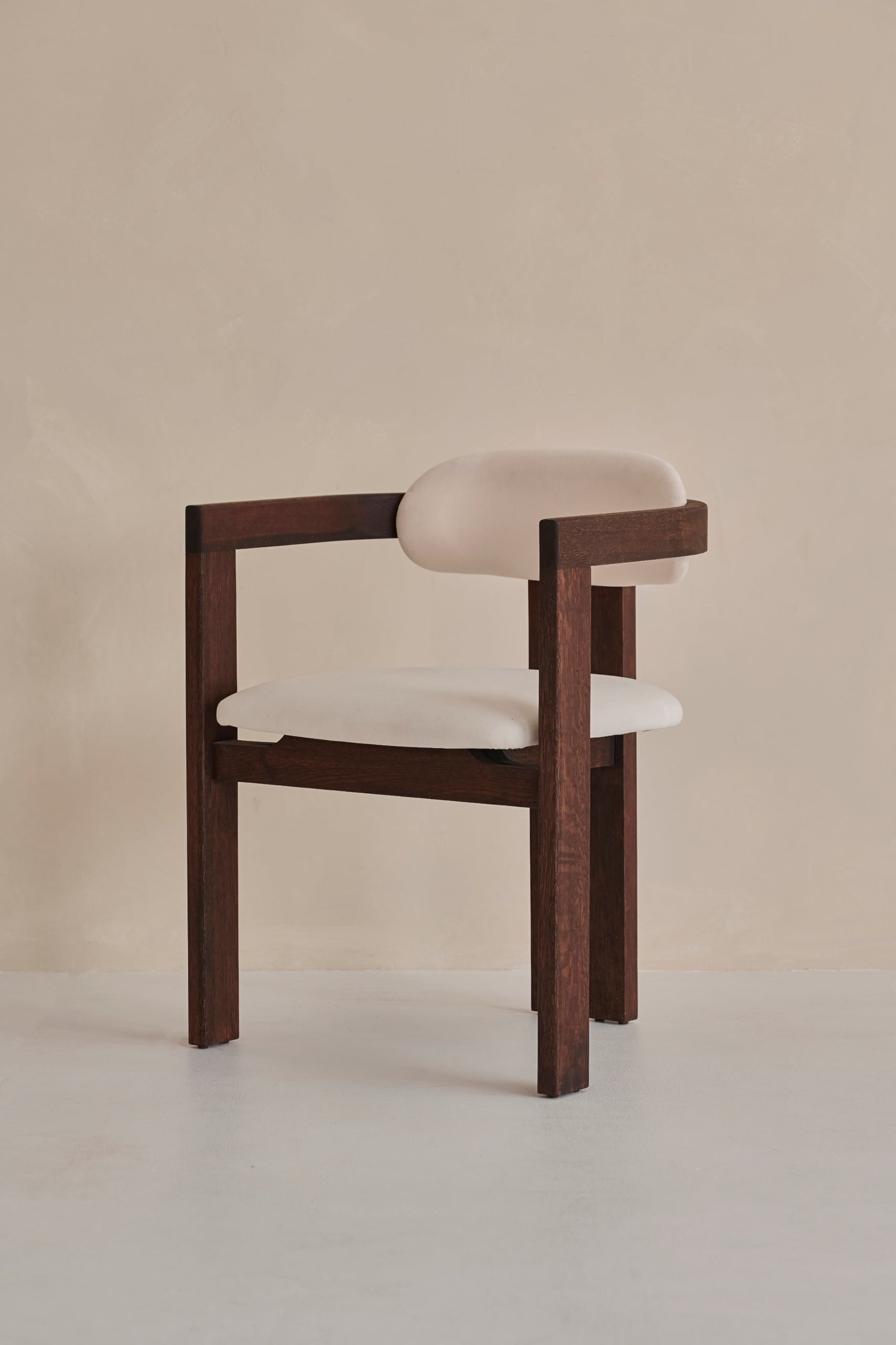 Aime Té Tribute dining chair with black frame and off-white upholstered seat, modern design, photographed from side angle.