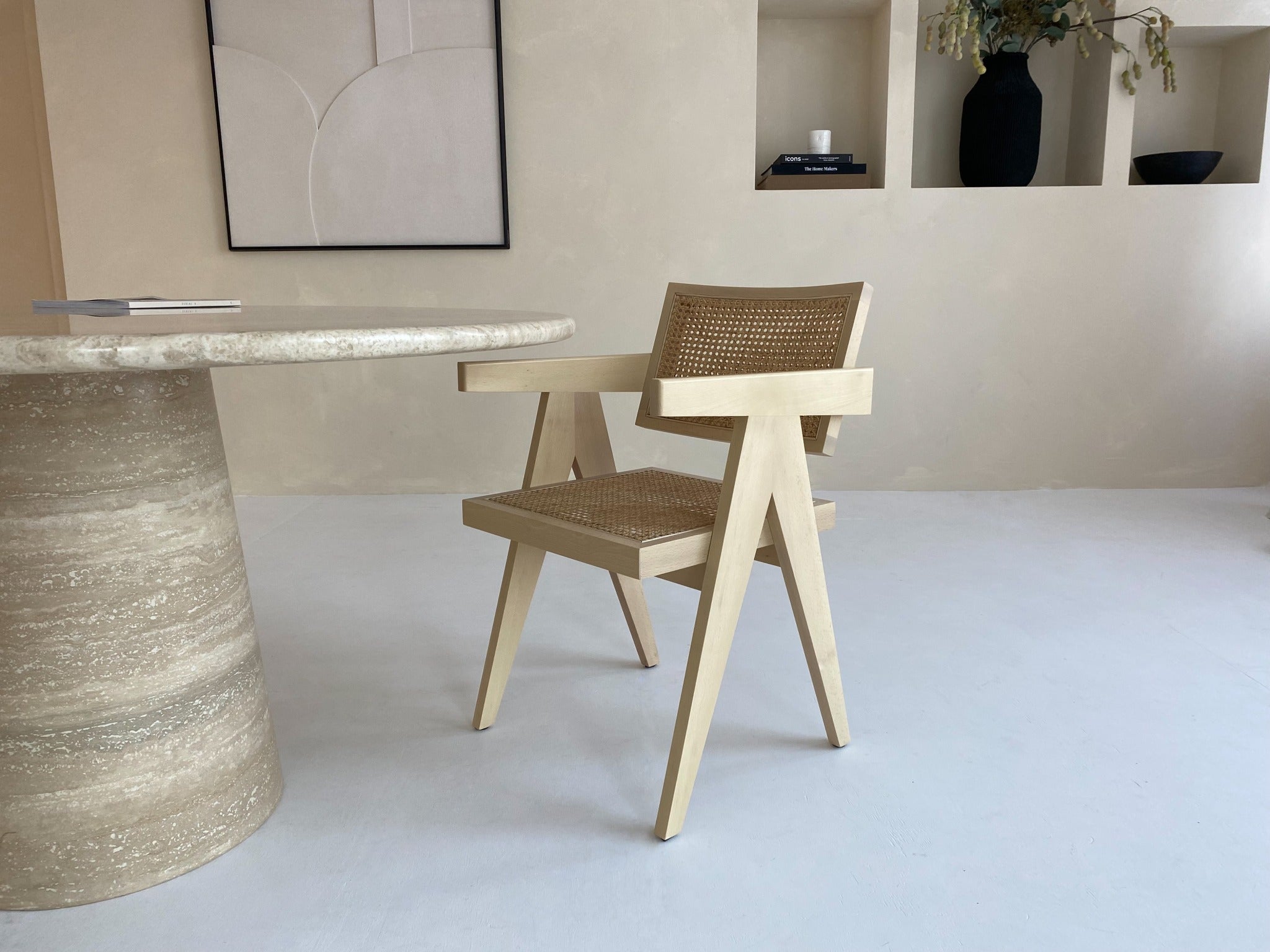 Natural rattan Pierre dining chair by Aime Té featuring a woven rattan seat and curved wooden legs.