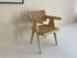 Natural rattan dining chair named Pierre by Aime Té, showcasing woven rattan seat and backrest with a sleek wooden frame.