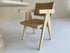 Natural rattan dining chair named Pierre by Aime Té, showcasing woven rattan seat and backrest with wooden legs.