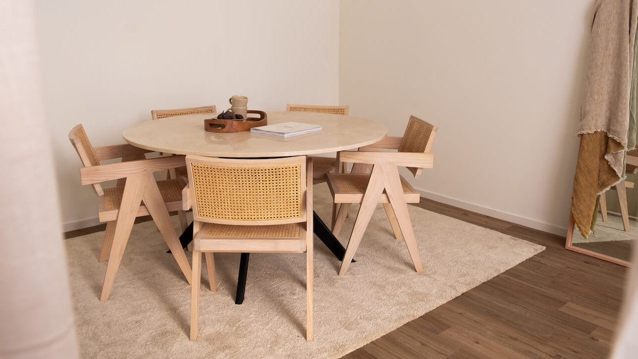 Glossy round marble dining table with Crema Marfil beige marble top and arch-shaped base by Aime Té.