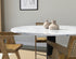 Round KIYO dining table with Bianco Carrara white marble top and grey-brown center leg, modern design, 110 cm diameter.