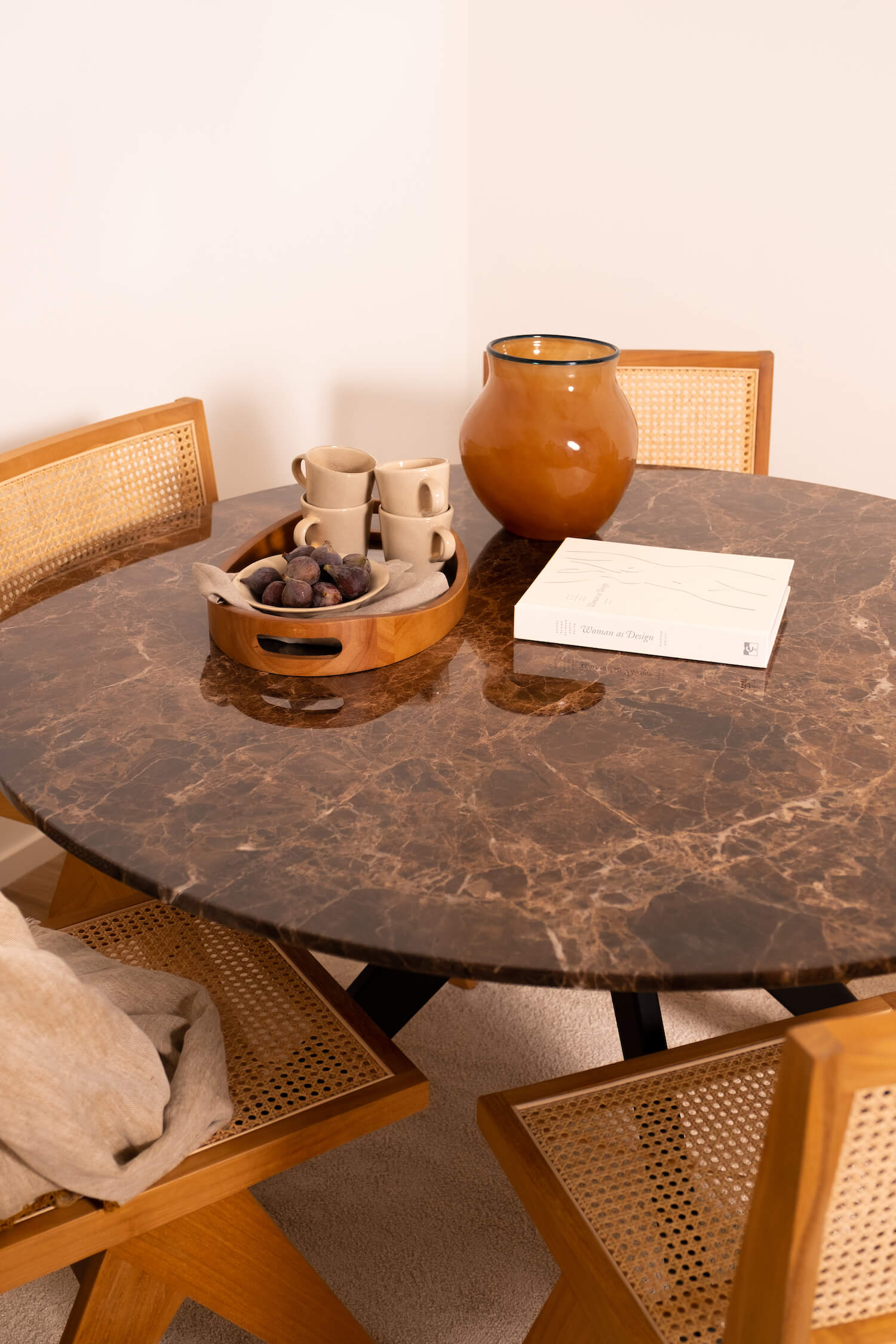 Round marble dining table with dark Emperador brown marble top and arch-style wooden legs, modern and elegant design.