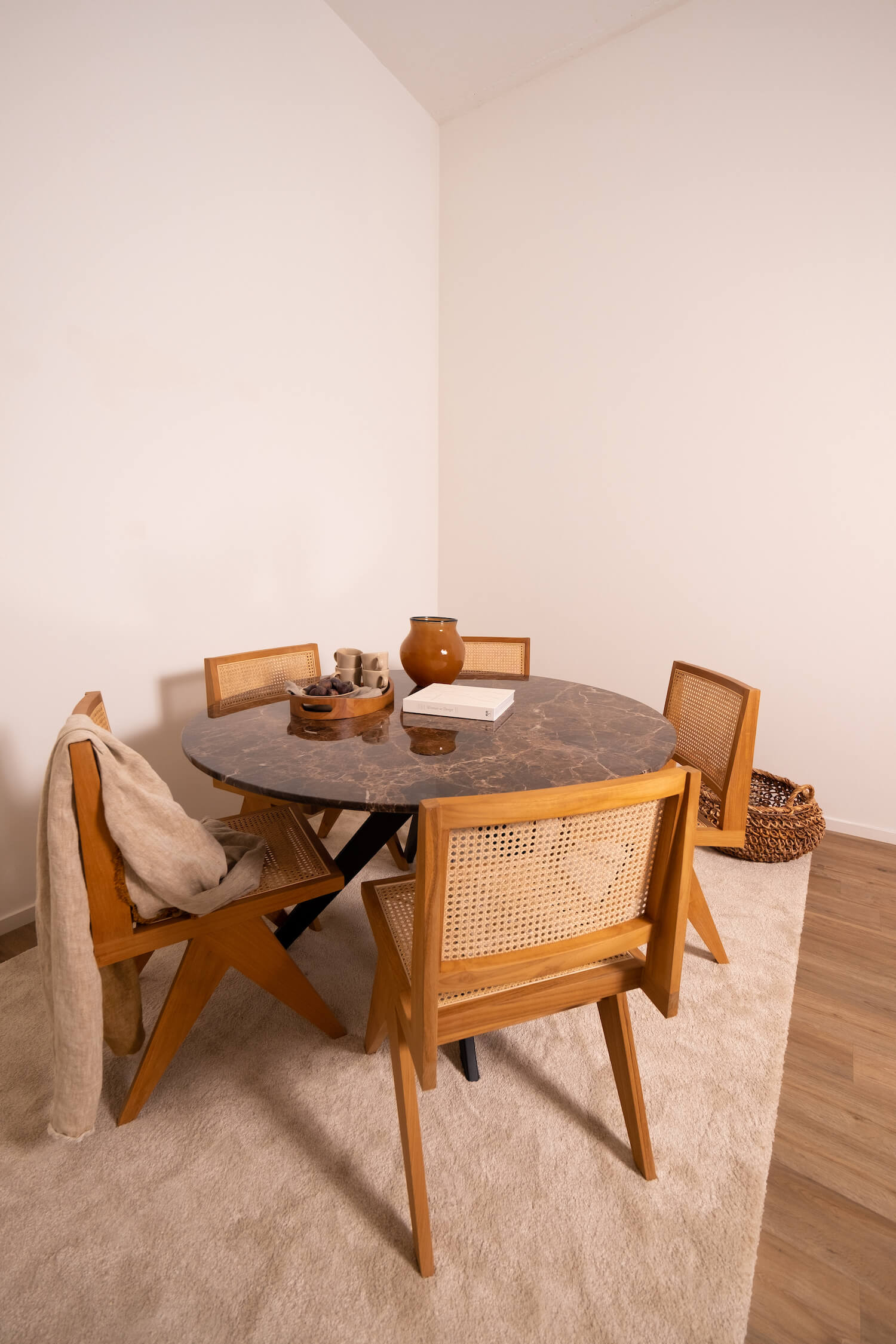 Round marble dining table with dark Emperador brown surface and arch-style metal frame, designed for elegant dining spaces.