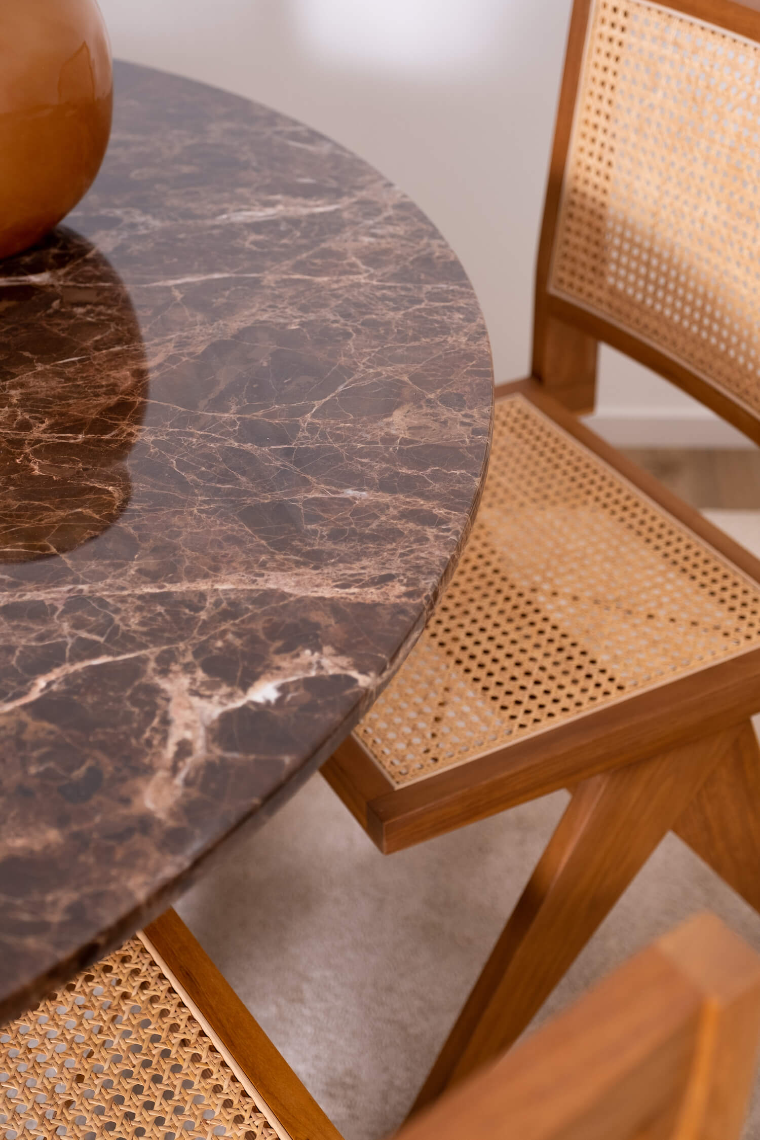 Dark Emperador brown round marble dining table with arch-style base, featuring a smooth marble surface and elegant design.