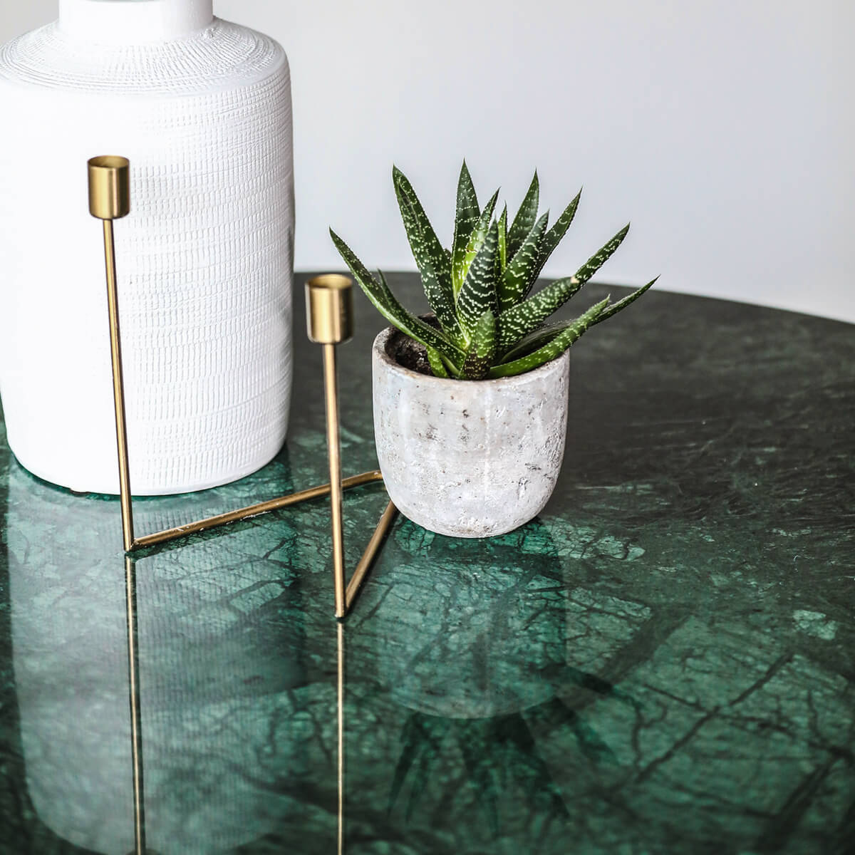 Round India Green marble dining table with arch-shaped metal legs, modern design, ideal for contemporary dining spaces.