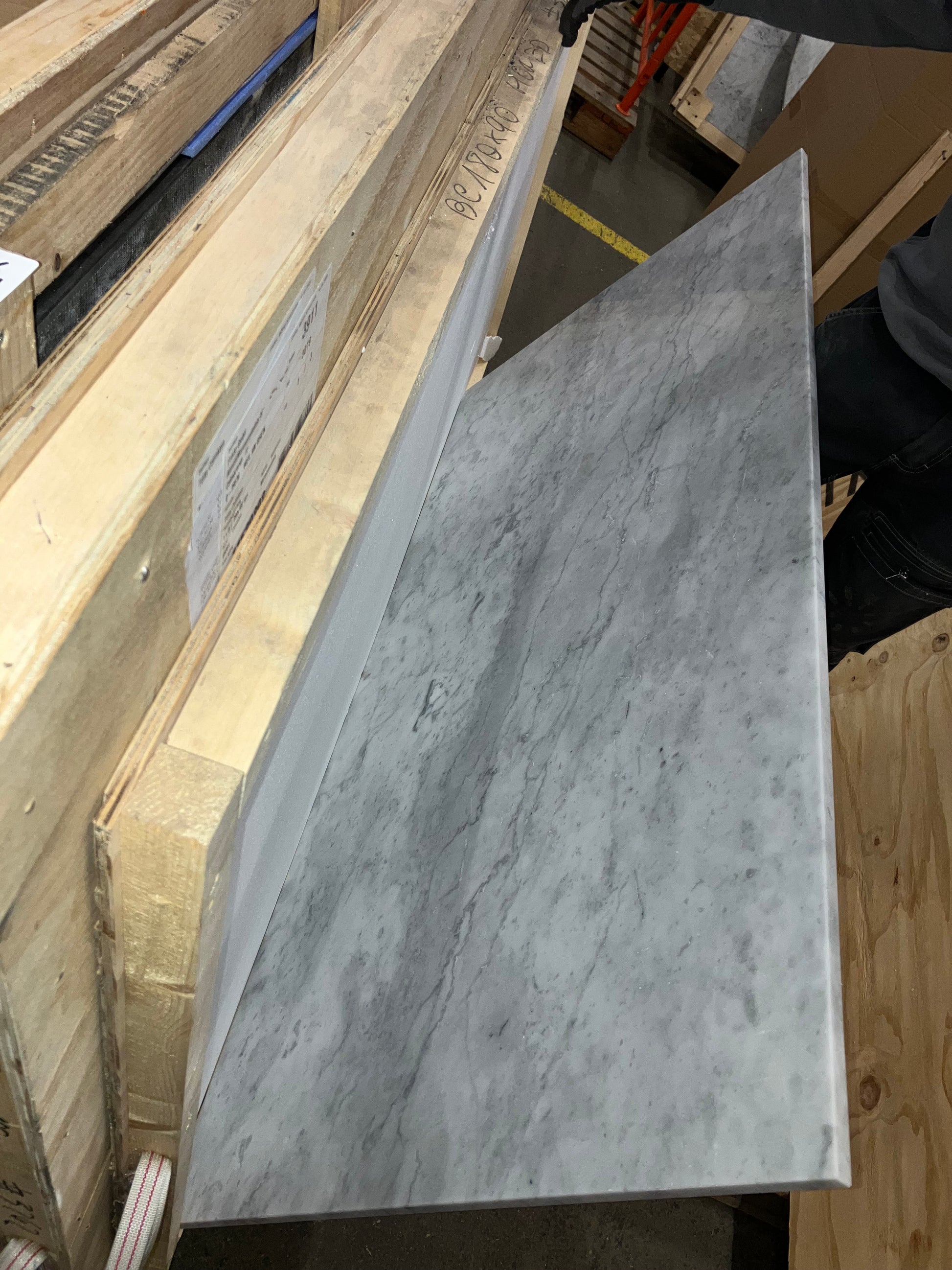 Rectangular marble dining table in Bianco Carrara White with four legs, matte finish, light edge damage visible in the image.