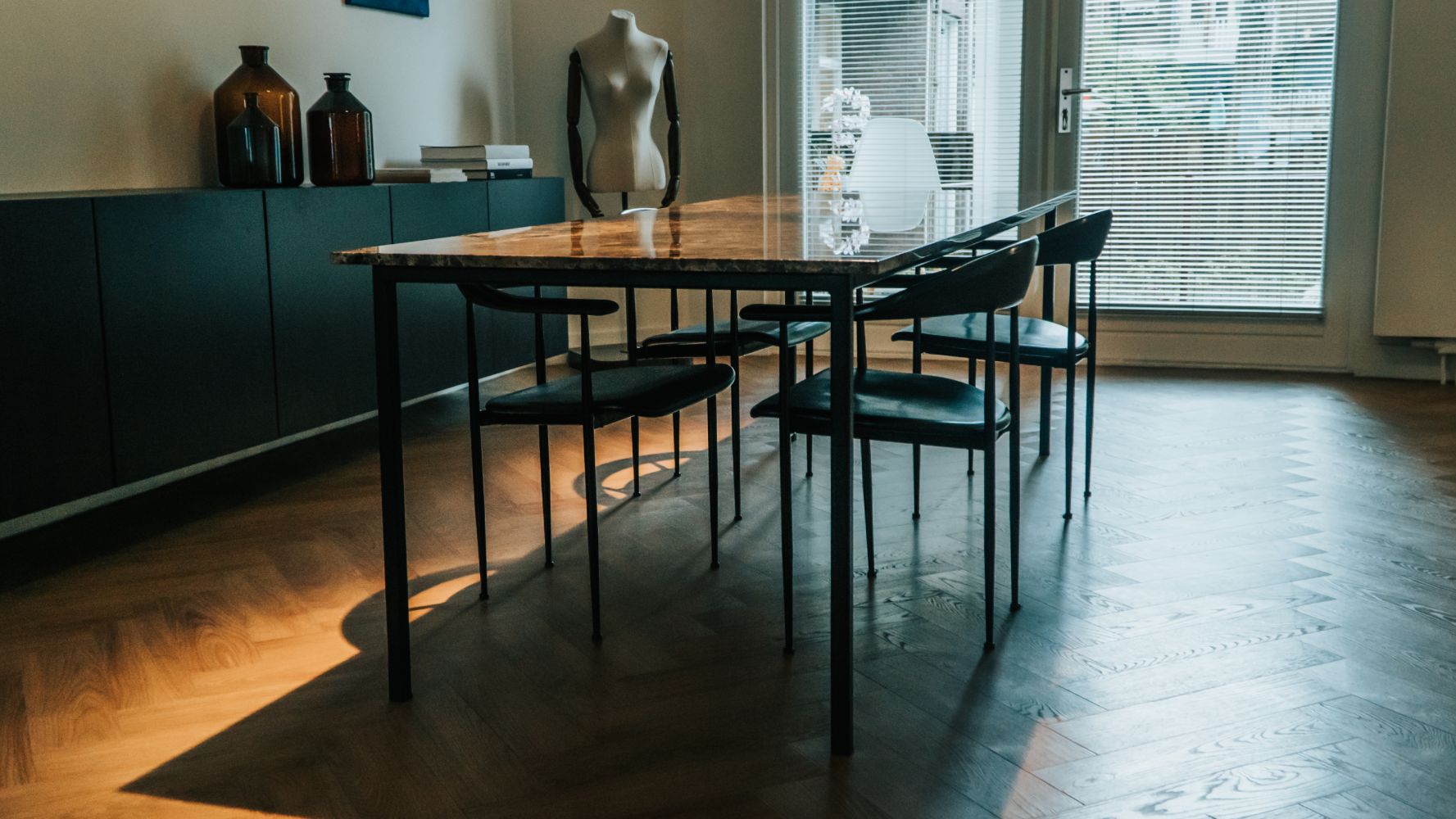 Rectangular marble dining table with dark Emperador brown finish, glossy surface, four-legged design, ideal for modern dining rooms
