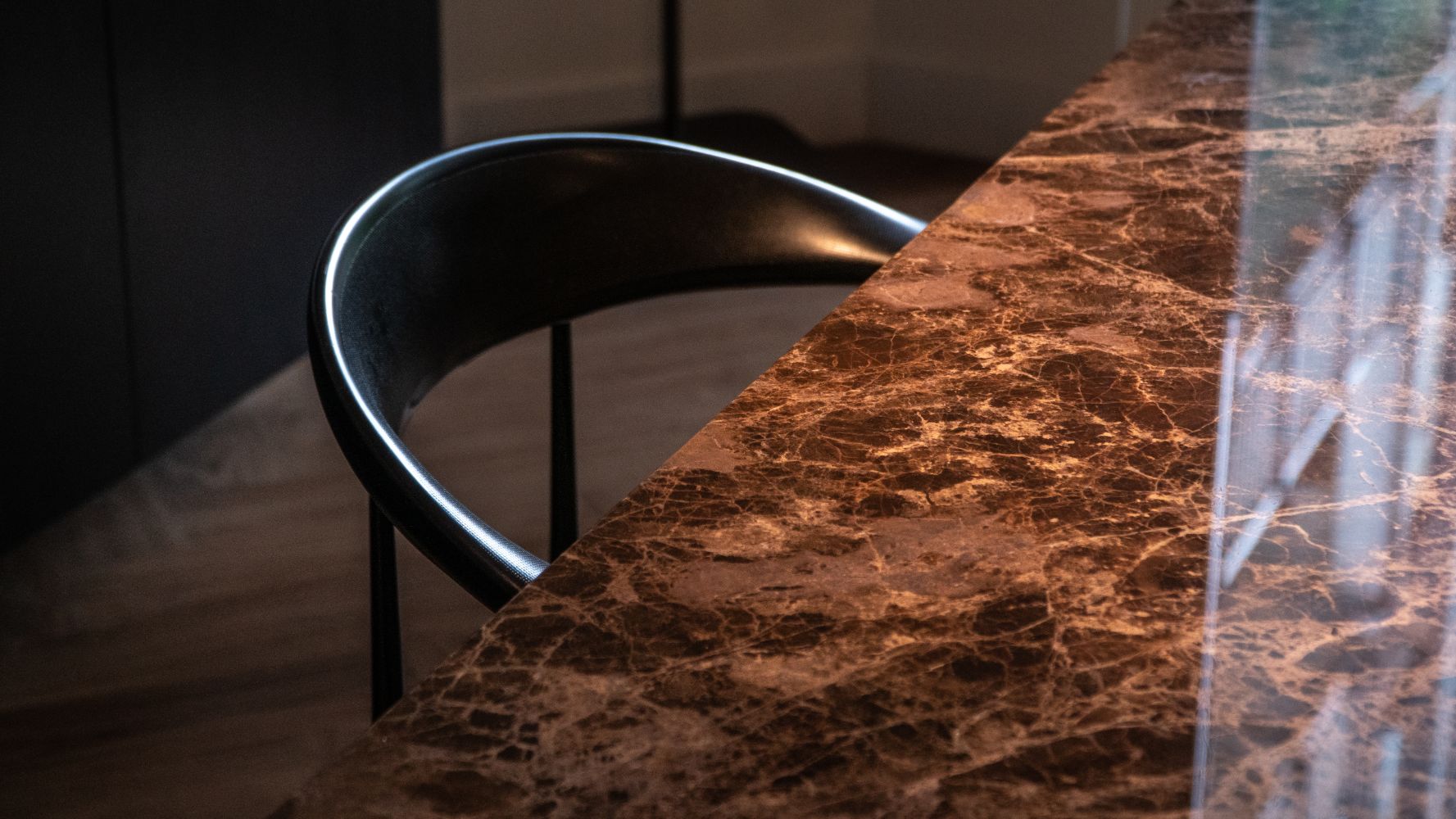 Rectangular marble dining table with dark Emperador brown finish, four-legged design, glossy surface, light stains, ideal for modern dining rooms.