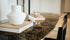 Dark Emperador brown Celio marble dining table with V-frame base, glossy finish, and modern design for elegant dining spaces.