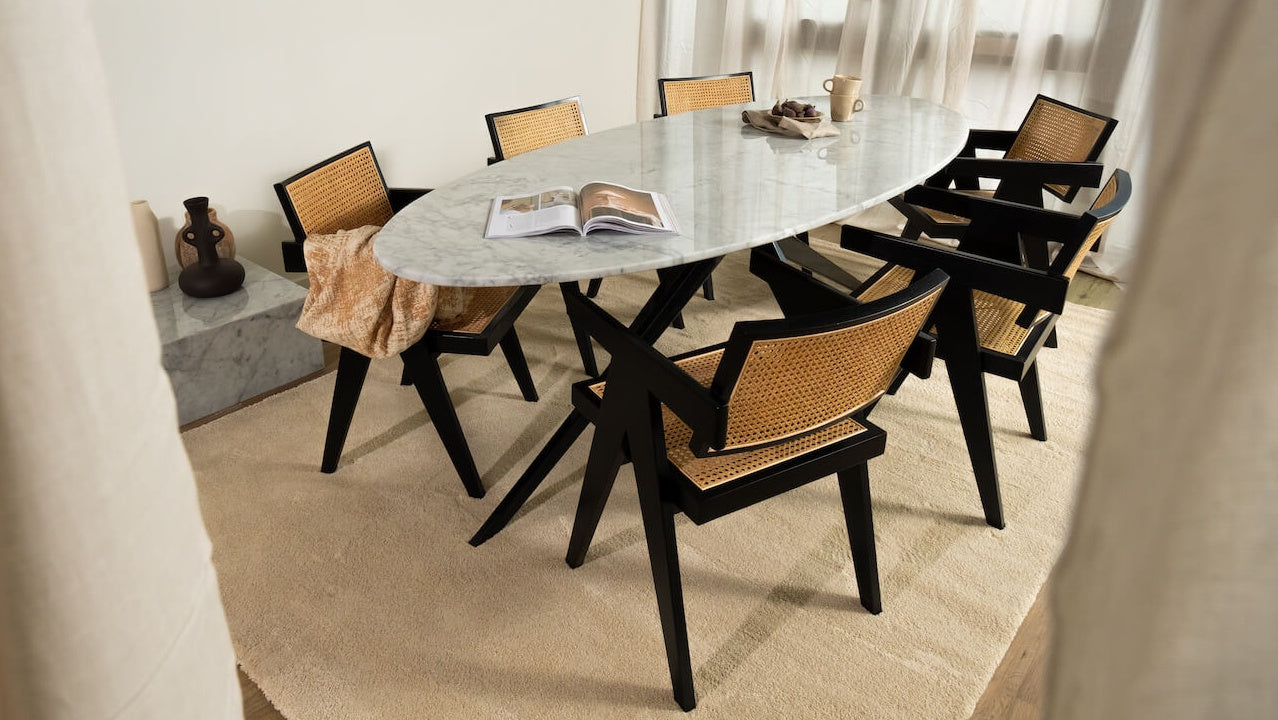 Glossy oval marble dining table with Bianco Carrara white surface and arch-style base, ideal for modern dining rooms.