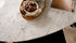 Glossy oval marble dining table with Bianco Carrara white surface and arch-style base, ideal for modern dining rooms.
