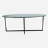 Glossy oval marble dining table with India Green marble top and cross-frame base, modern and elegant design.