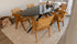 Glossy oval Nero Marquina marble dining table with black arch frame, showcasing sleek, modern design and polished surface.