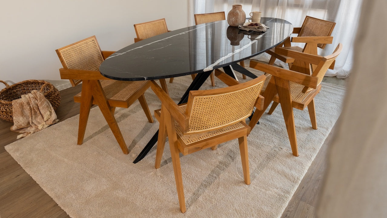 Glossy oval Nero Marquina marble dining table with black arch frame, showcasing sleek, modern design and polished surface.