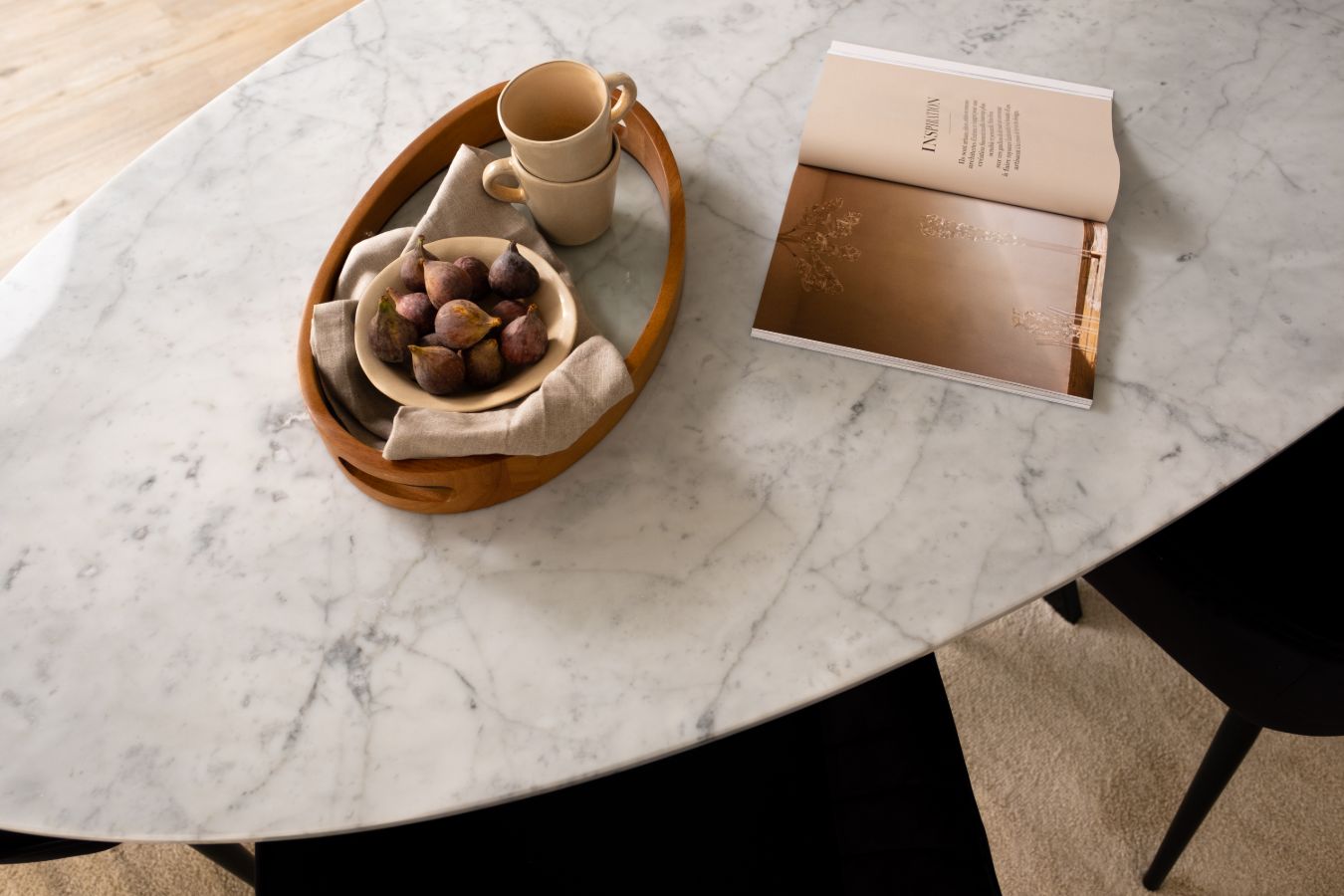 Oval marble dining table with Bianco Carrara white marble top and cross metal frame, matte grey tint with small scratches.