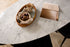 Oval marble dining table with Bianco Carrara white marble top and cross metal frame, matte grey tint with small scratches.