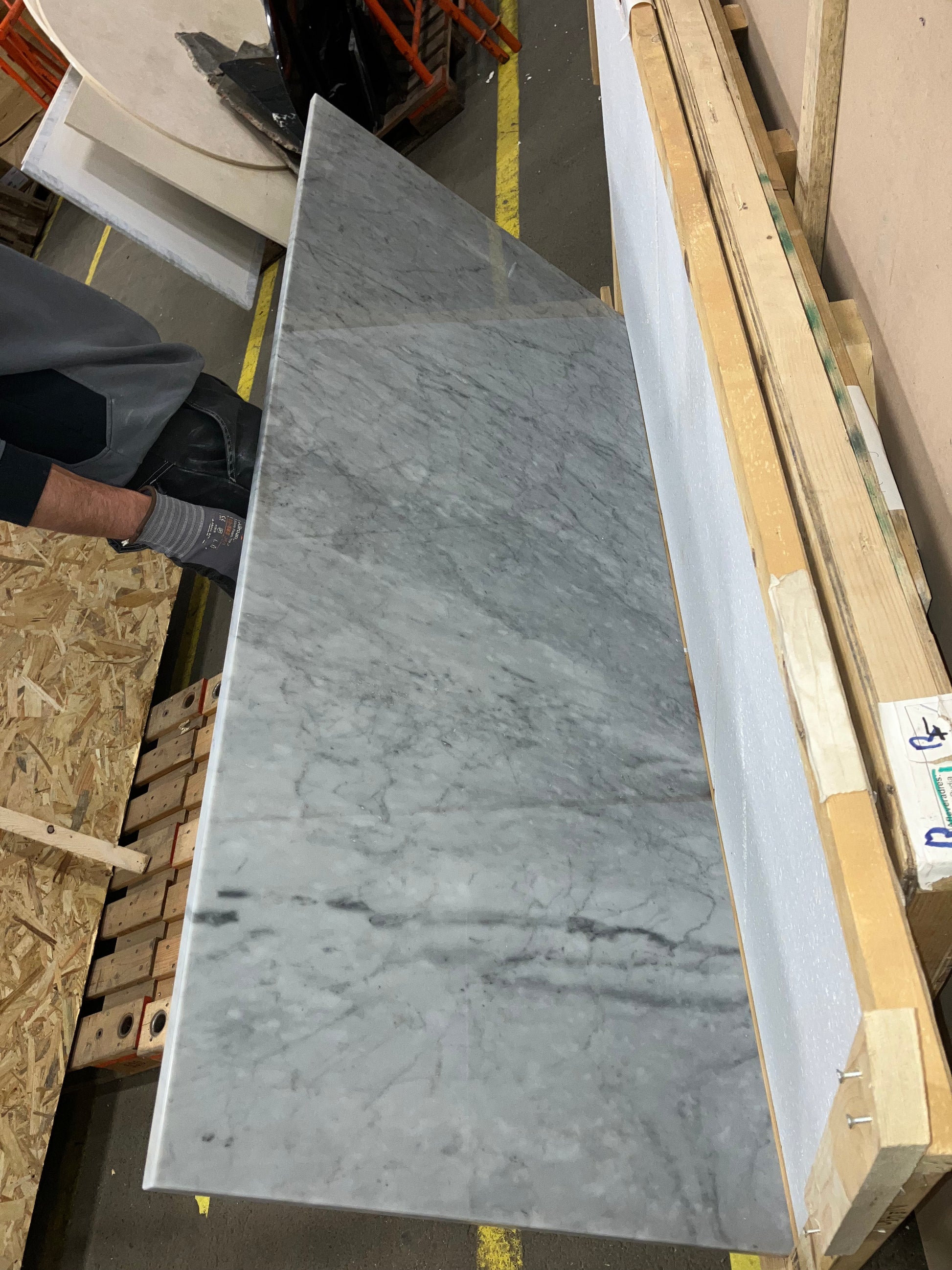 Rectangular marble dining table in Bianco Carrara White with four legs, matte grey tint and subtle black mark.