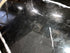 Oval Nero Marquina marble dining table with cross-frame base, glossy finish showing stains and scratches, 180x90 cm.