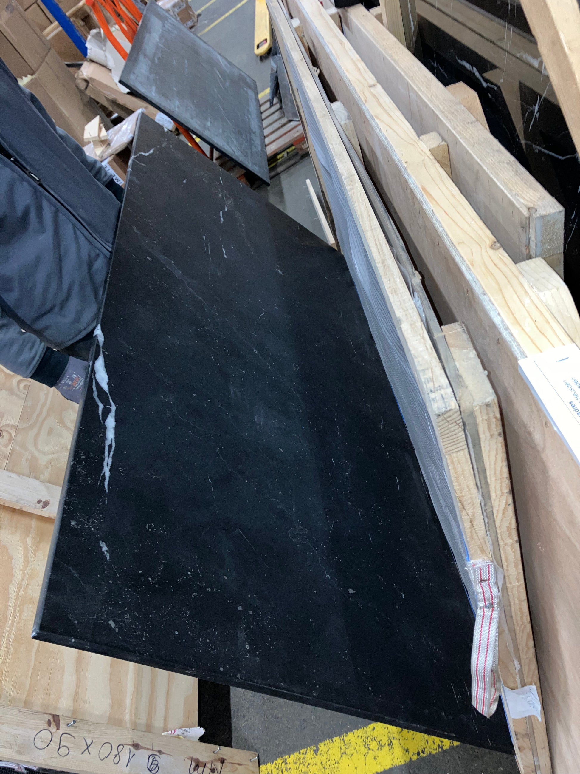 Rectangular Nero Marquina black marble dining table with U-frame, matte finish, showing light scratches and damaged edges.