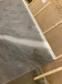 Rectangular marble dining table with white Bianco Carrara marble top, four grey metal legs, and matte finish.