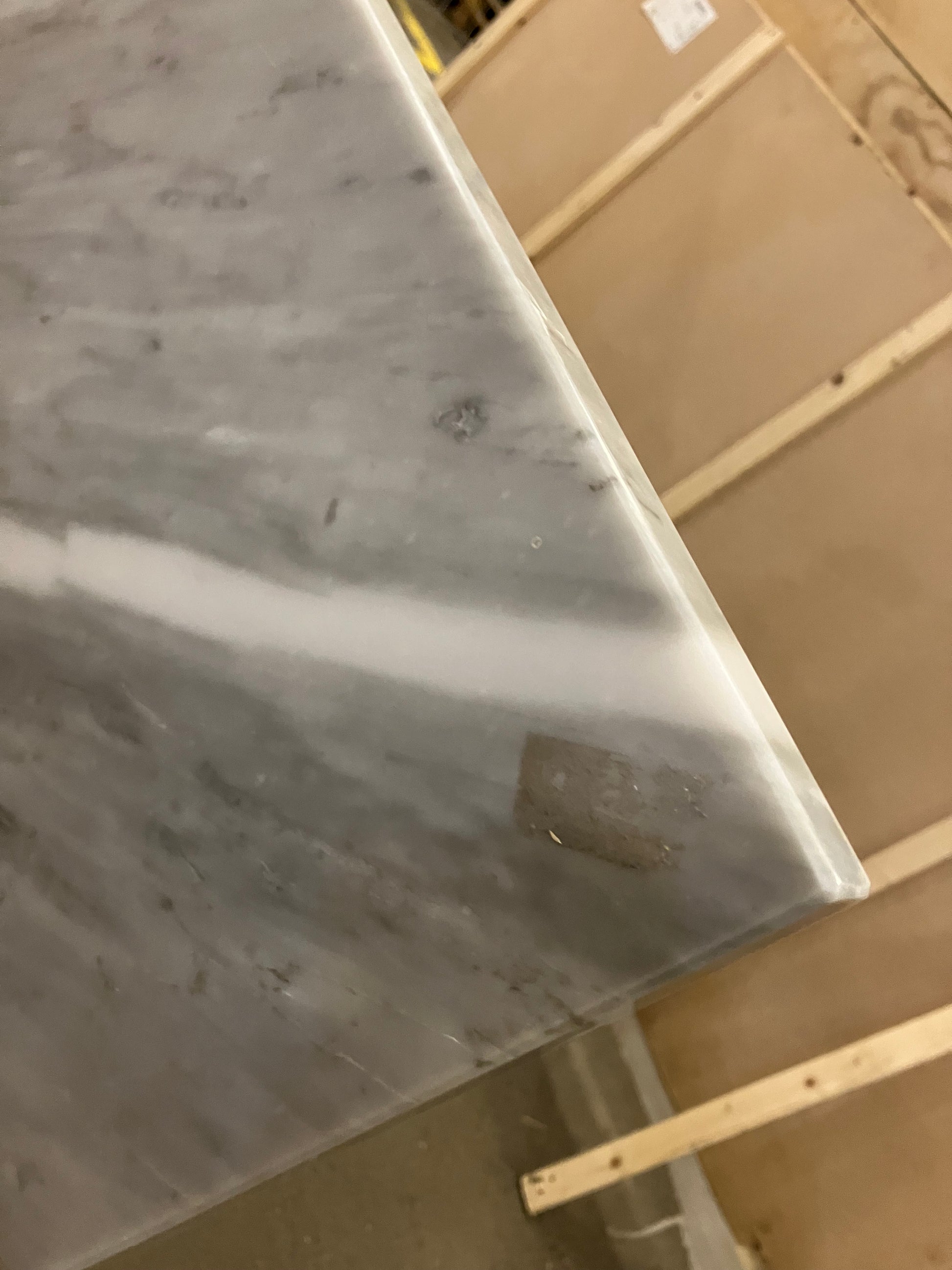 Rectangular marble dining table with white Bianco Carrara marble top, four grey metal legs, and matte finish.