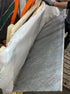 Rectangular marble dining table in Bianco Carrara White with four legs, matte finish, small side damage barely visible.