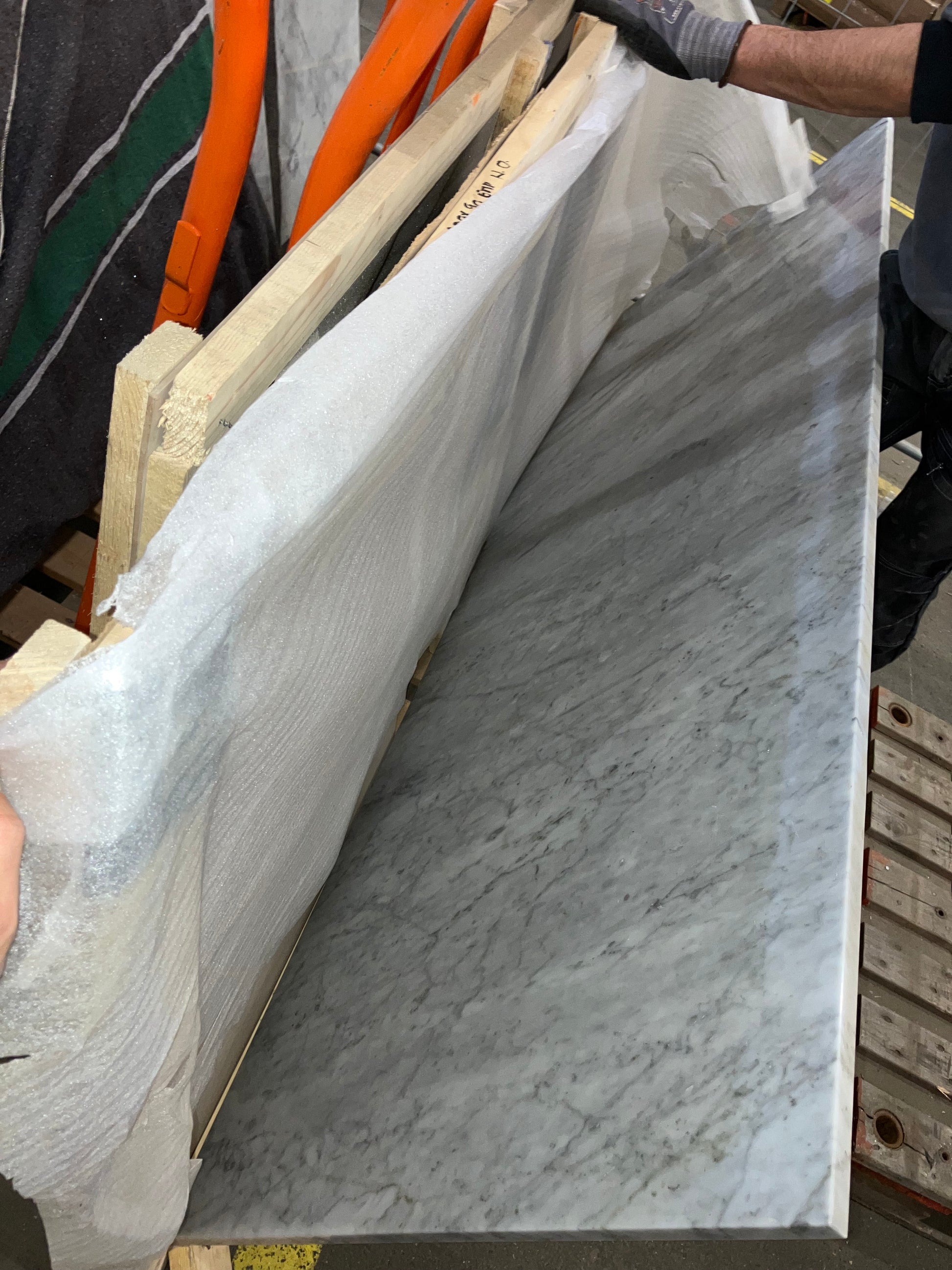 Rectangular marble dining table in Bianco Carrara White with four legs, matte finish, small side damage barely visible.
