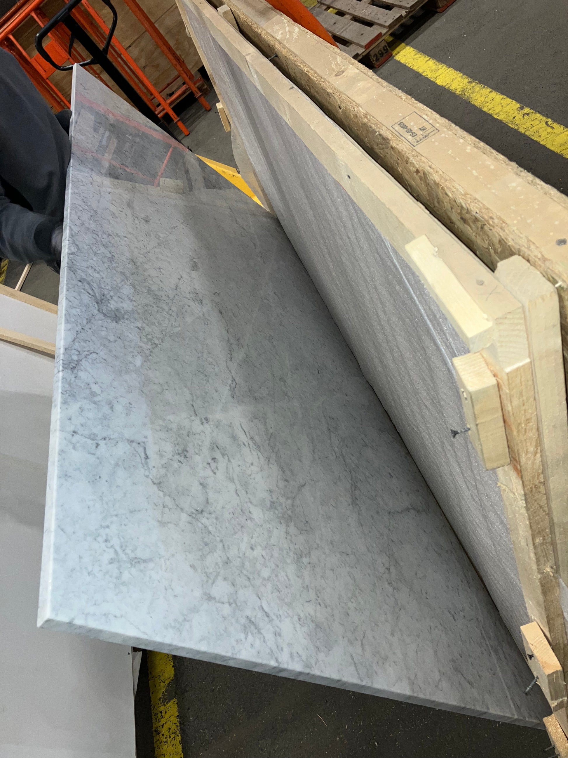 Rectangular marble dining table with white Bianco Carrara marble surface, four legs, glossy finish, minor scratches visible.