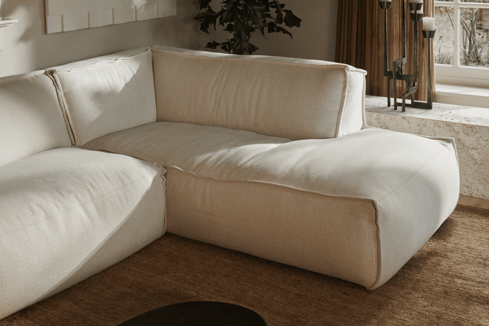 Three-seater YUTO Sofa in Phoebe Beige with plush cushions, showcasing a modern design and soft fabric upholstery.