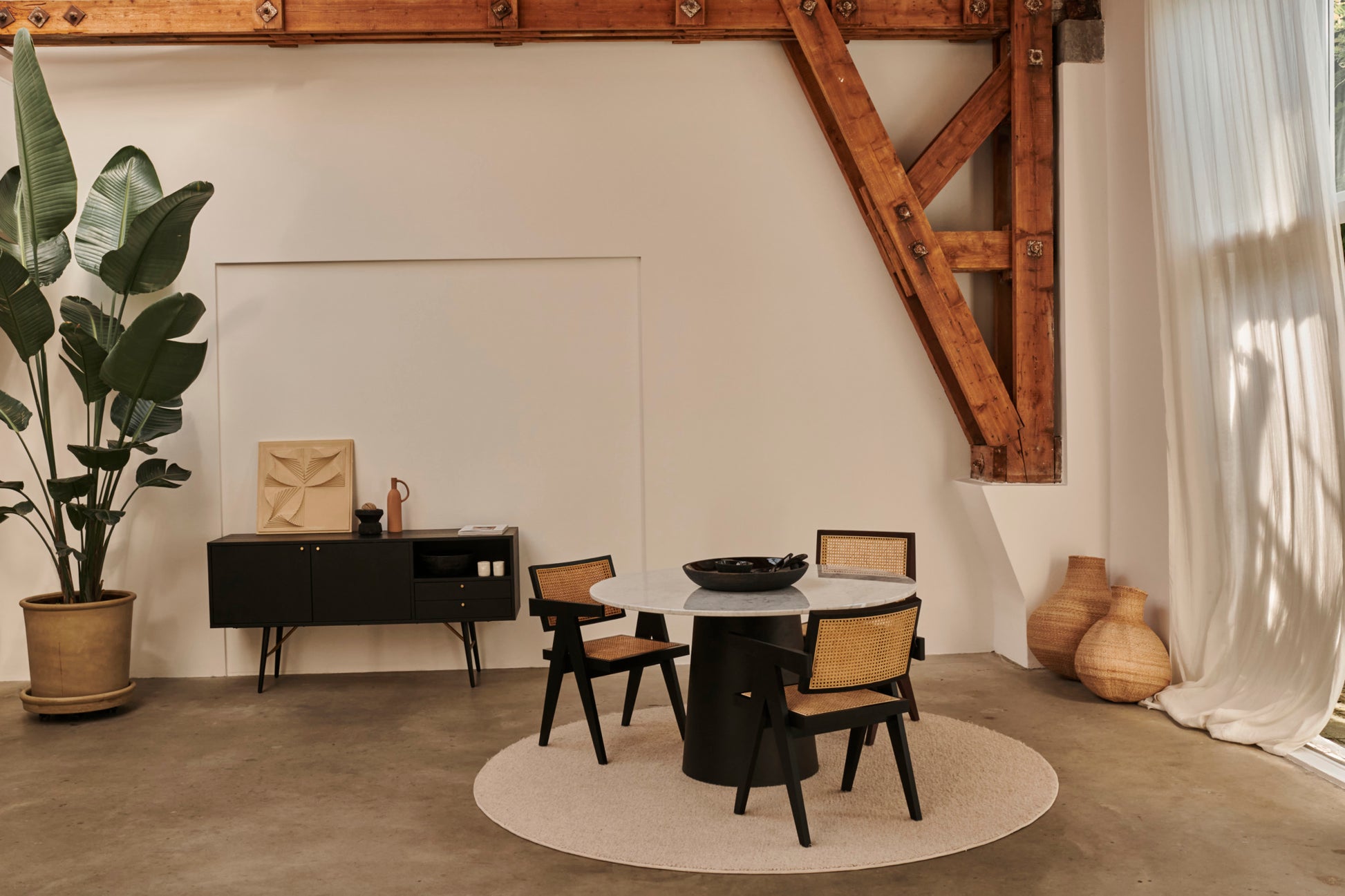 Flow oval dining table with Crema Altea marble top and black cylindrical base, modern design for stylish dining spaces.