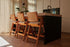 Off-white upholstered barstool with brown Pierre frame, modern design, featuring a comfortable seat and sturdy construction.