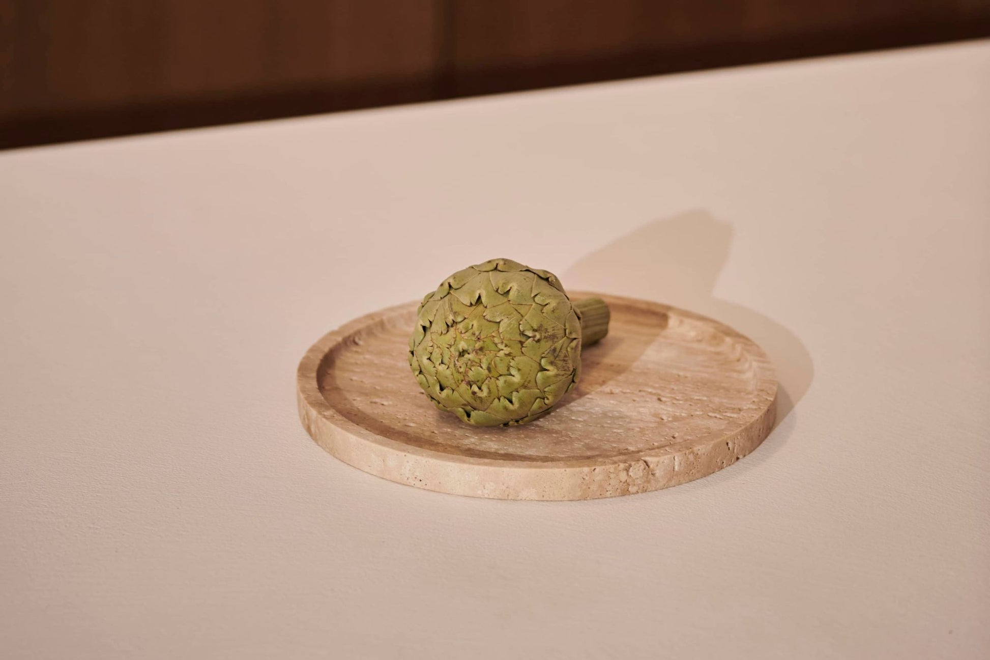 Round Artifakt collection tray made of natural travertine stone, showcasing a stylish and durable design.
