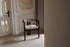 Black upholstered dining chair with liver-colored seat cushion from the Tribute collection, featuring a modern design.