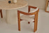 Upholstered off-white dining chair with brown legs from the TRIBUTE collection, showcasing a comfortable seat and modern design.