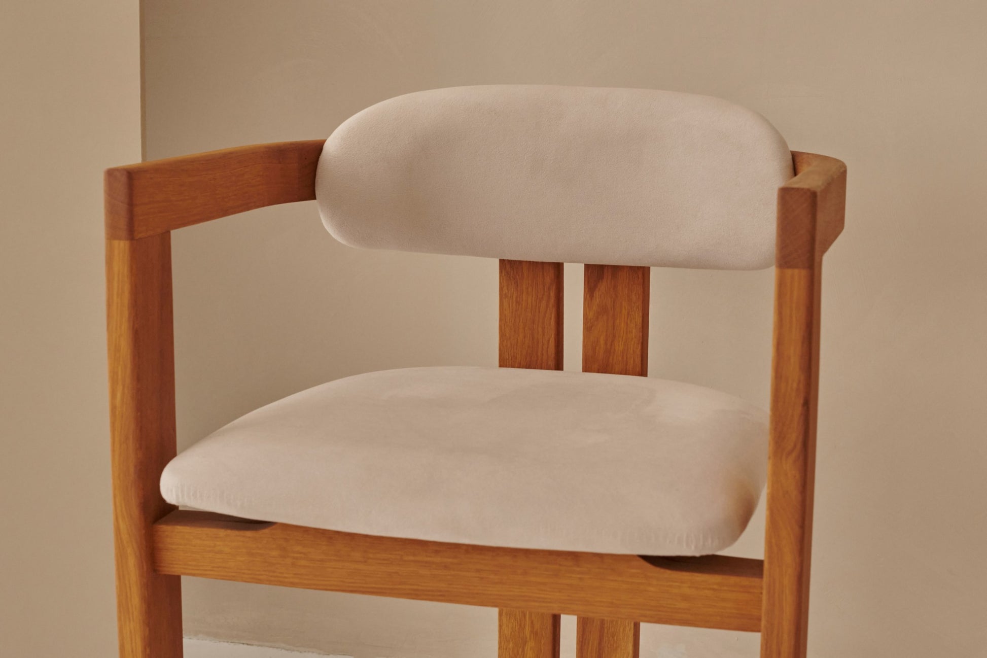 Upholstered off-white dining chair with brown legs from the Tribute collection, showcasing a comfortable, modern design.