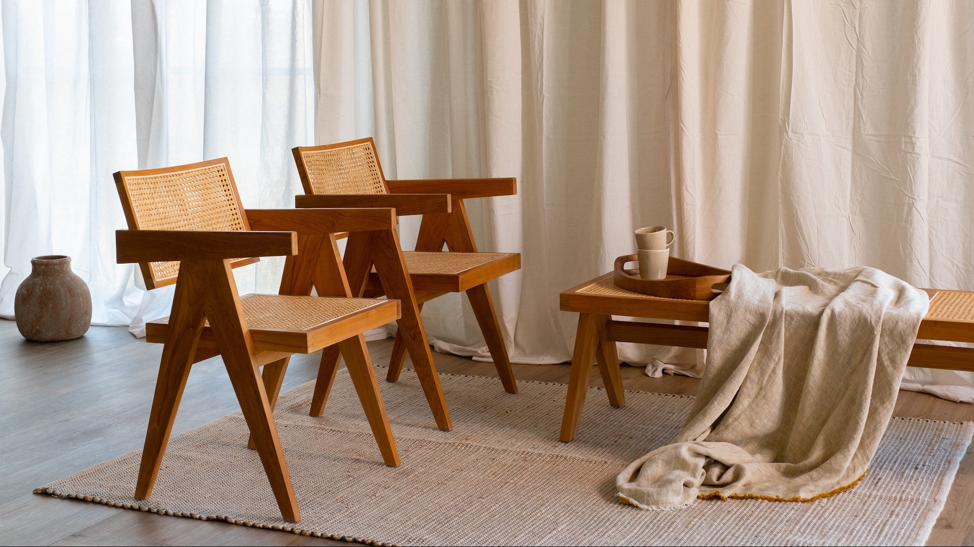 Brown rattan bench named Pierre with a sturdy wooden frame, perfect for indoor or outdoor seating.