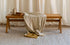 Brown rattan bench named Pierre with a sturdy frame, perfect for indoor or outdoor seating.
