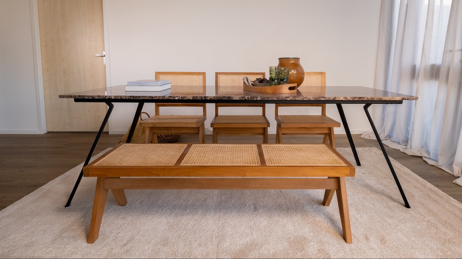 Brown rattan bench named Pierre with a sturdy frame and woven rattan seating, perfect for indoor or outdoor use.