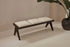 Dark brown rattan bench with upholstered seat named Pierre, stylish and sturdy for indoor or outdoor use.