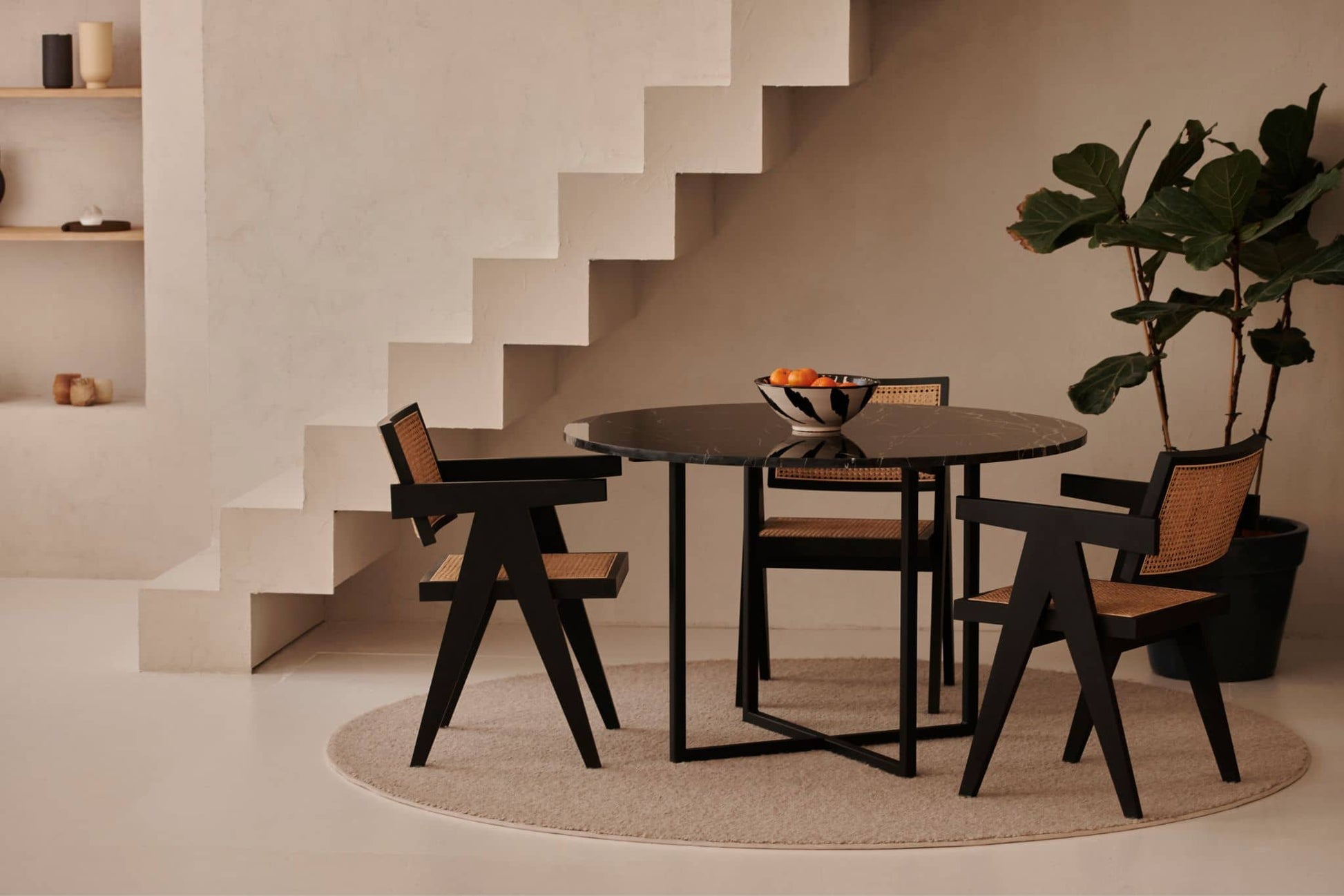 Black rattan dining chair named Pierre with a sleek design, featuring woven rattan seat and backrest for stylish dining room decor.