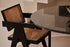 Black rattan dining chair named Pierre with a modern design, featuring a sturdy frame and stylish woven rattan seat and back.