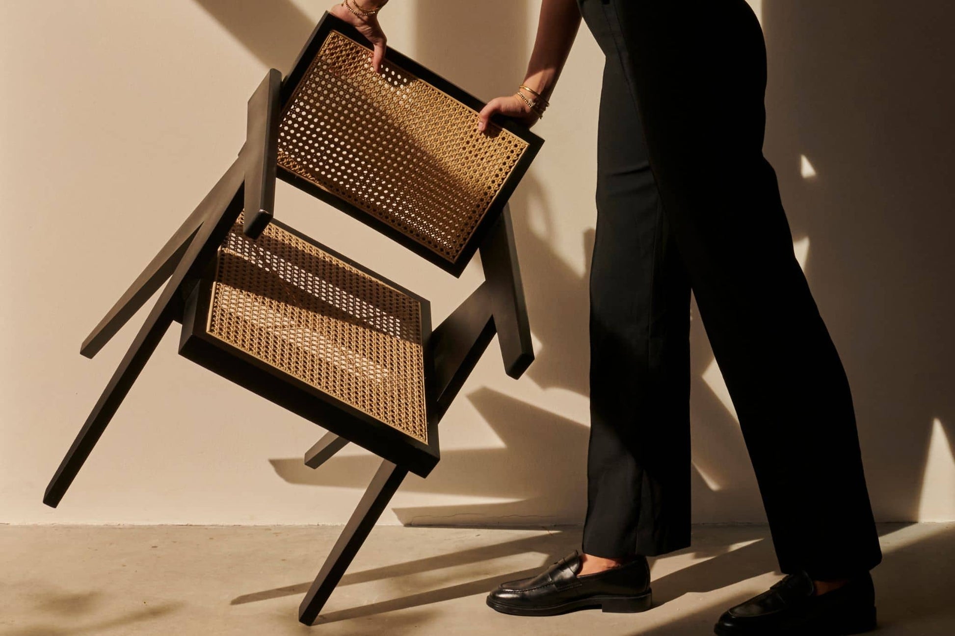 Black rattan dining chair named Pierre with a modern design, featuring a sturdy frame and woven rattan seat.
