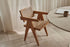 Brown rattan dining chair named Pierre with a natural woven seat and curved armrests, perfect for stylish dining spaces.
