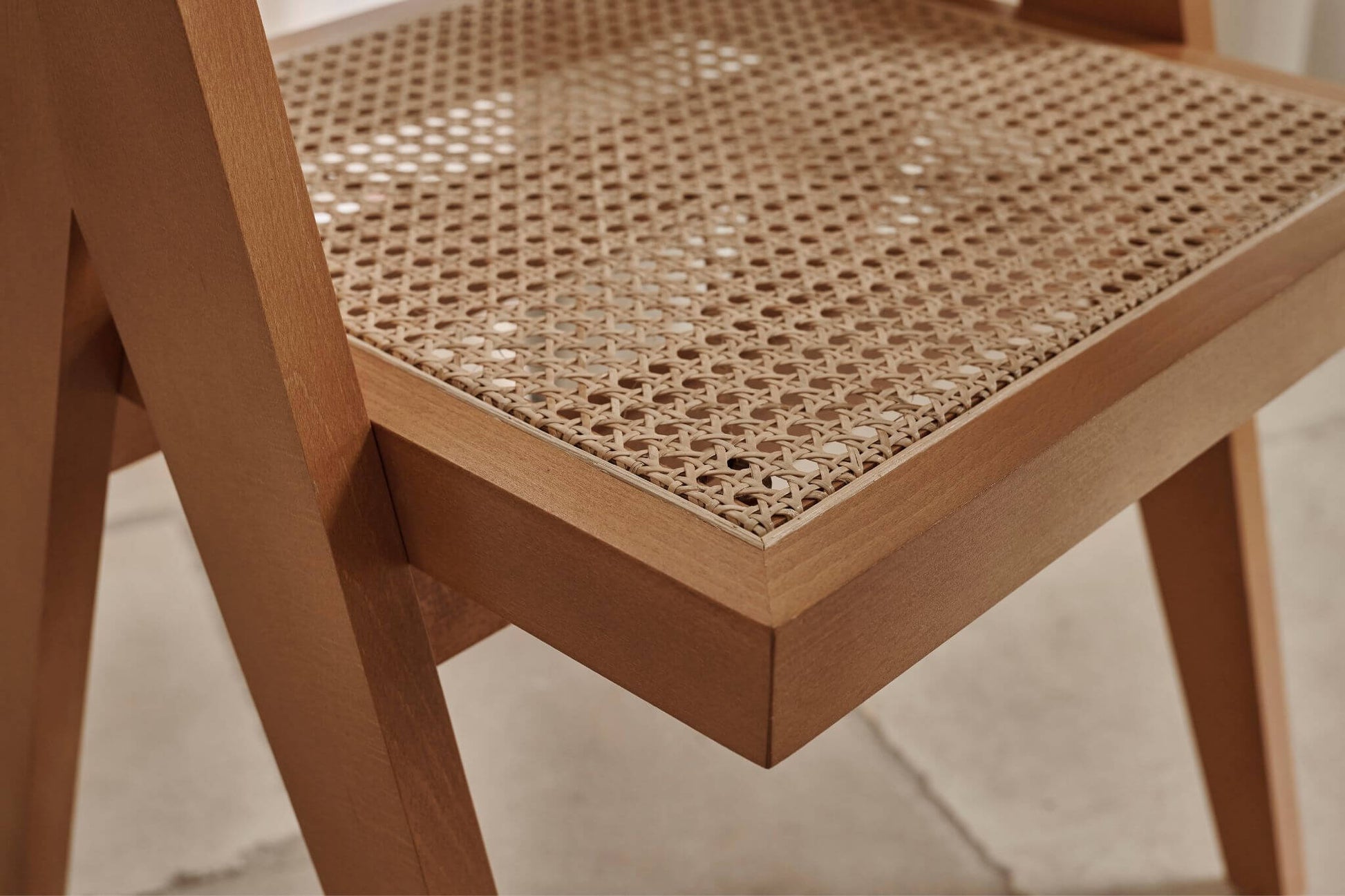 Brown rattan dining chair named Pierre, featuring a woven rattan design with a sturdy frame for comfortable seating.