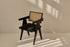 Black rattan dining chair with upholstered seat and Pierre design, showcasing a modern and stylish seating option.