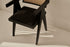 Black rattan dining chair with upholstered seat, stylish Pierre design, featuring a modern and comfortable look for dining spaces.