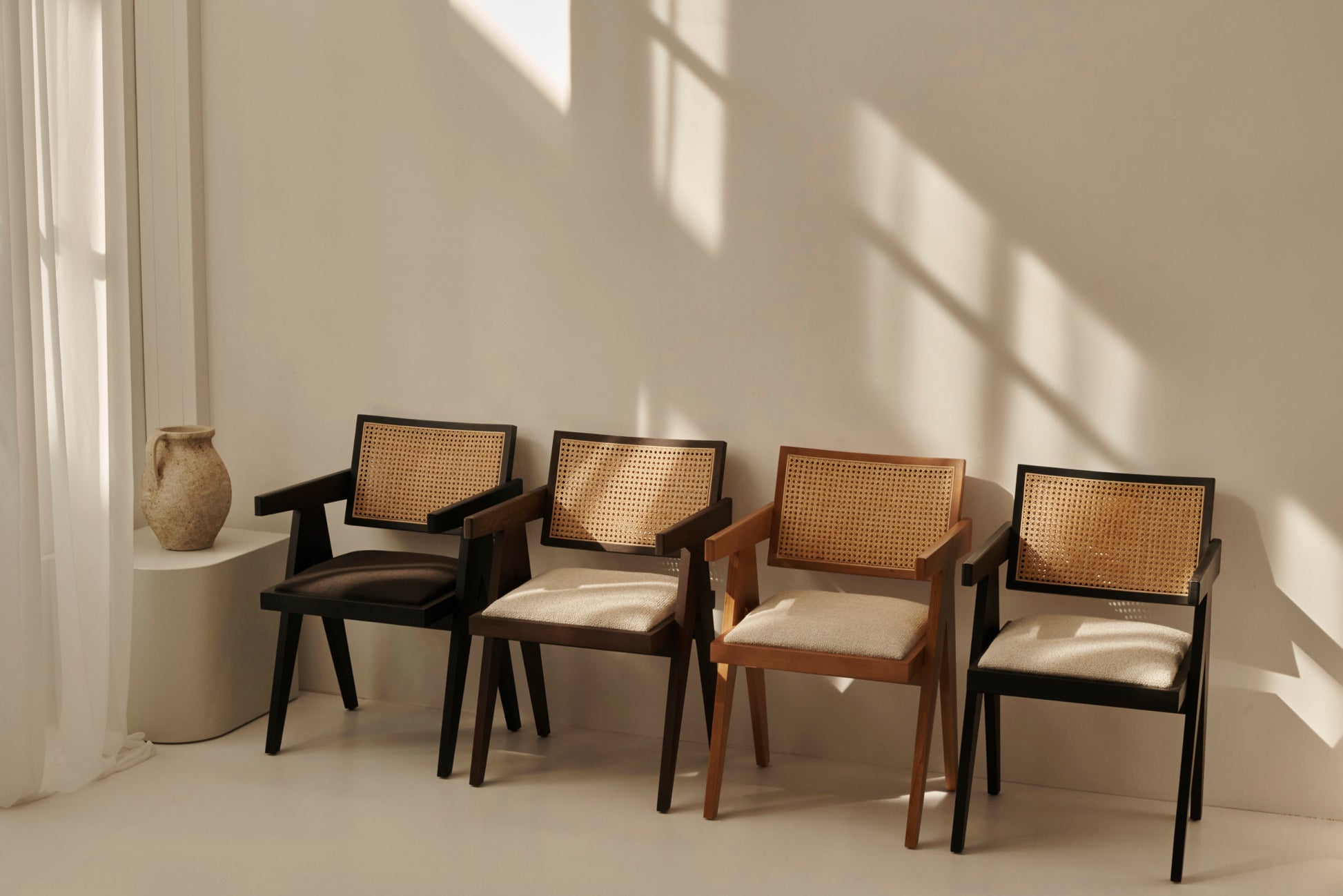 Black rattan dining chair with upholstered seat and Pierre design, showcasing a stylish and comfortable seating option.
